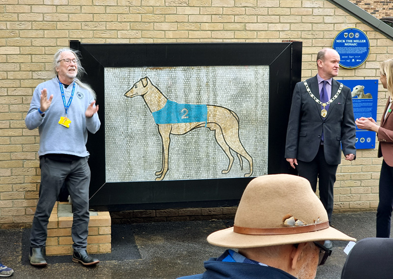 Jojhn Lynch from WiSH giving a speech beside the unveiling of the Mick the Miller mosaic.